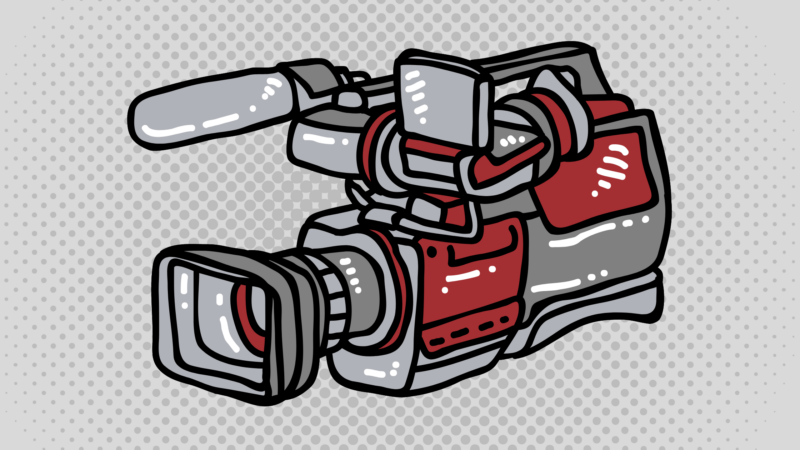 The image shows a stylized illustration of a video camera with red and gray colors. The camera has a large lens, a microphone on top, and various buttons and components visible. The background consists of a pattern of gray dots.