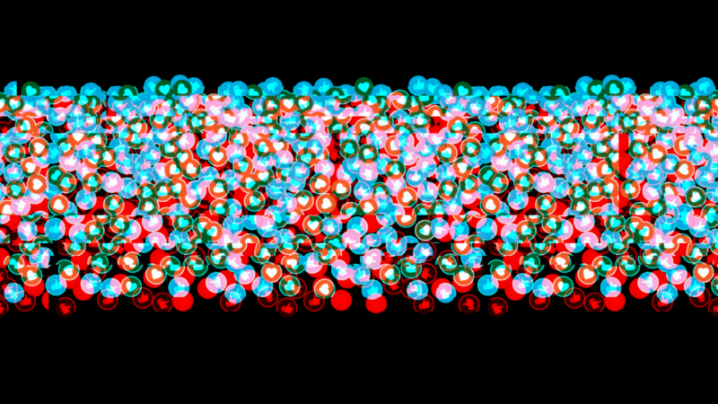 The image shows a dense arrangement of colored spheres, primarily in red, blue, and green hues, against a black background. The spheres appear to be overlapping and densely packed in a horizontal band across the image.