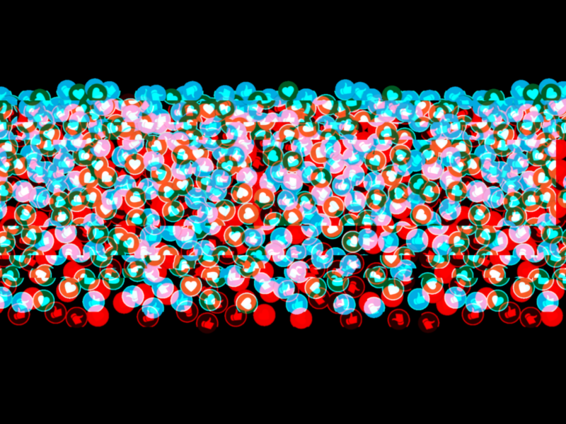 The image shows a dense arrangement of colored spheres, primarily in red, blue, and green hues, against a black background. The spheres appear to be overlapping and densely packed in a horizontal band across the image.