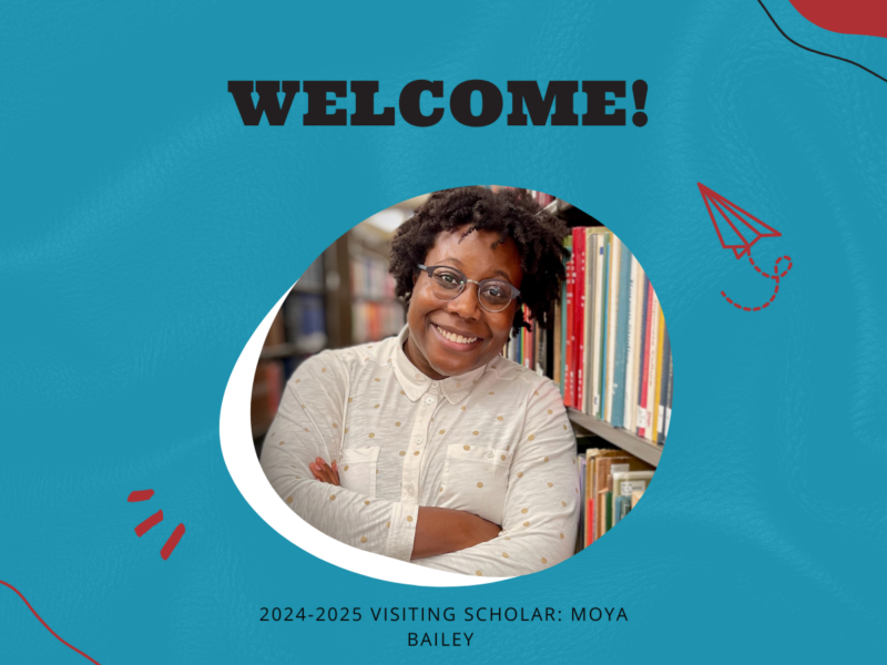 The image shows a person standing in front of a bookshelf with arms crossed. The background is blue with red accents, and there is text on the image that reads: "WELCOME! 2024-2025 VISITING SCHOLAR: MOYA BAILEY."