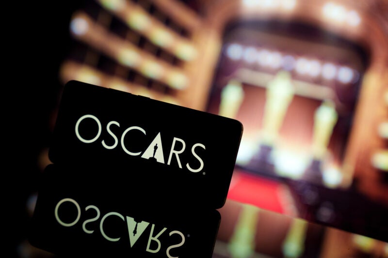A smartphone displaying the Oscars logo against a blurred awards ceremony background. January 13, 2025