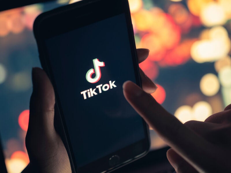 Tik Tok application icon on iPhone 11 pro max screen in hand and have a bokeh for background. Tiktok social media network.May 7, 2021, Bangkok, Thailand